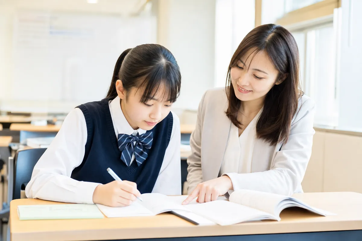先生がそばで宿題を見守る教室の様子